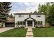 Charming two-story home with manicured lawn, lush trees, and inviting entryway at 3930 S Hillcrest Dr, Denver, CO 80237