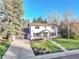 Charming two-story home featuring a well-manicured lawn, a gray attached garage, and a walkway leading to the front door at 3930 S Hillcrest Dr, Denver, CO 80237