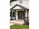 Charming entryway featuring a modern black double door, brick accents and a covered porch at 3930 S Hillcrest Dr, Denver, CO 80237