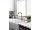 Farmhouse sink with bronze faucet and large window providing ample natural light at 3930 S Hillcrest Dr, Denver, CO 80237