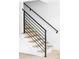 Modern staircase features light wood treads and sleek, black metal railings at 3930 S Hillcrest Dr, Denver, CO 80237