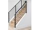 Modern staircase features light wood treads and sleek, black metal railings at 3930 S Hillcrest Dr, Denver, CO 80237