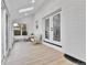 Bright sunroom with skylight, white brick accent wall, and neutral color furniture at 3930 S Hillcrest Dr, Denver, CO 80237