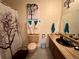 A well-lit bathroom with tree themed shower curtain, unique sink and toilet at 22400 County Road 10, Hudson, CO 80642