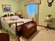 This bedroom boasts a floral quilt, window with lace curtain, and an antique wooden chest at the foot of the bed at 22400 County Road 10, Hudson, CO 80642