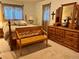 Well-lit bedroom shows a four-poster bed and a wooden bench with a large dresser and mirror set at 22400 County Road 10, Hudson, CO 80642