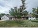 Charming home featuring stone accents, mature trees, and a spacious front yard at 22400 County Road 10, Hudson, CO 80642