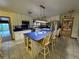 Bright kitchen features white cabinets, a blue island with seating, and open shelving for storage at 22400 County Road 10, Hudson, CO 80642
