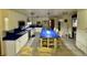 Bright open kitchen with blue countertops, white cabinets, a center island with bar seating, and stainless appliances at 22400 County Road 10, Hudson, CO 80642