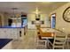 Spacious kitchen with a dining area, featuring white cabinets, a blue island, and tile flooring at 22400 County Road 10, Hudson, CO 80642