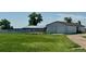 Open view of the property's outbuildings, including a white storage shed and barn, set against a backdrop of lush greenery at 22400 County Road 10, Hudson, CO 80642