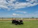 Antique trailer with a hay bail on a green lawn with a view at 22400 County Road 10, Hudson, CO 80642