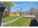 Well-maintained backyard featuring lush lawn, stone pathway, wooden fence, shed, and a view of surrounding neighborhood at 3680 S Logan St, Englewood, CO 80113