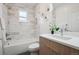 Bright bathroom features tiled shower over tub and wood vanity with white countertop at 3680 S Logan St, Englewood, CO 80113