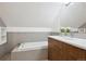 Bright bathroom with soaking tub, wood vanity, white countertop and large mirror at 3680 S Logan St, Englewood, CO 80113