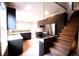 Modern kitchen featuring dark cabinets, stainless steel appliances, light wood flooring and stair access at 3680 S Logan St, Englewood, CO 80113