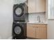 Convenient laundry room featuring a stackable washer and dryer and modern cabinets at 3680 S Logan St, Englewood, CO 80113