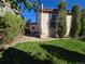 Backyard featuring a lush green lawn, manicured landscaping, and a window with privacy blinds at 1927 Rannoch Dr, Longmont, CO 80504