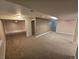Spacious finished basement with neutral carpet, paint, and view into storage area at 1927 Rannoch Dr, Longmont, CO 80504