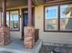 Inviting front door with brick column accents and neutral colored siding for great curb appeal at 1927 Rannoch Dr, Longmont, CO 80504