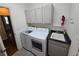Laundry room featuring white cabinets, gray counters, a utility sink, and modern washer and dryer at 1927 Rannoch Dr, Longmont, CO 80504