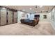Entertainment room with a cozy sectional couch, carpet floors, and a large sliding barn door in the basement at 2272 Front Range Rd, Erie, CO 80516