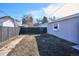 Backyard featuring a fence, grass yard, and modern gray home at 1680 Syracuse St, Denver, CO 80220