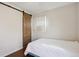 Cozy bedroom with a wooden sliding barn door and a bright window at 1680 Syracuse St, Denver, CO 80220