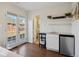 Bright kitchenette featuring granite countertop, stainless steel mini-fridge, and floating shelving with plants at 1680 Syracuse St, Denver, CO 80220