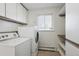 Functional laundry room with updated washer and dryer and ample storage shelves at 1680 Syracuse St, Denver, CO 80220