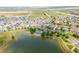 Aerial view of a scenic lakefront property featuring a charming gazebo and mature trees along the shoreline at 18173 E 104Th Way, Commerce City, CO 80022