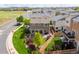 Aerial view of a well-maintained backyard with lush greenery and a charming paver patio at 18173 E 104Th Way, Commerce City, CO 80022