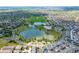 Picturesque aerial view of a community with a lake, park, pool, and recreational facilities at 18173 E 104Th Way, Commerce City, CO 80022
