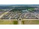 Scenic aerial view of a neighborhood with lush green spaces, a tranquil lake, and distant mountain views at 18173 E 104Th Way, Commerce City, CO 80022
