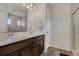 Bathroom featuring double sinks, dark wood cabinets, and a tiled shower at 18173 E 104Th Way, Commerce City, CO 80022