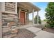 Inviting front porch with stone accents, cozy seating, and a well-manicured landscaped entrance at 18173 E 104Th Way, Commerce City, CO 80022