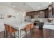 Modern kitchen with an island, stainless steel appliances, pendant lighting, and rich hardwood floors at 18173 E 104Th Way, Commerce City, CO 80022