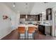 Bright kitchen featuring an island with seating, stainless steel appliances, and dark cabinets at 18173 E 104Th Way, Commerce City, CO 80022