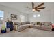 Spacious living room with a sectional sofa, a ceiling fan, and natural light at 18173 E 104Th Way, Commerce City, CO 80022