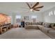 Spacious living room with large sectional couch, ceiling fan, and natural light from bright windows at 18173 E 104Th Way, Commerce City, CO 80022