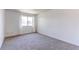 Bright bedroom features neutral carpeting, window offering natural light, and freshly painted white walls at 8798 Chase Dr # 2, Arvada, CO 80003