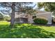 Landscaped townhome exterior with a fenced yard, mature trees, and well-maintained lawn at 8798 Chase Dr # 2, Arvada, CO 80003