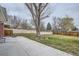 Expansive backyard featuring a well-maintained lawn, mature tree, and a paved patio area for outdoor enjoyment at 6970 Upham St, Arvada, CO 80003