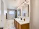 Bright bathroom with double sinks, modern lighting fixtures, and white marble flooring at 6970 Upham St, Arvada, CO 80003