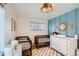 Stylish Bedroom with two cribs, a white dresser, and blue paneled accent wall at 6970 Upham St, Arvada, CO 80003