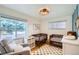 Sunlit Bedroom with two cribs, a comfortable armchair, and a playful area rug at 6970 Upham St, Arvada, CO 80003