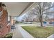 Comfortable seating area on the front porch of a charming brick home at 6970 Upham St, Arvada, CO 80003