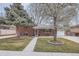 Charming brick home with a well-manicured front yard and beautiful, mature trees at 6970 Upham St, Arvada, CO 80003