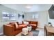 Inviting living room featuring an orange sectional sofa, plush rug, and bright windows at 6970 Upham St, Arvada, CO 80003