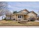 Tan one-story house with a covered porch and landscaped yard at 9748 W Peakview Dr, Littleton, CO 80123